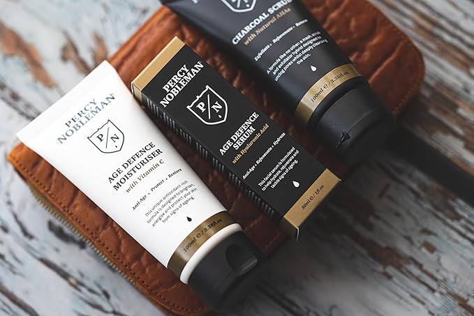 Age Defence Kit, a men's skincare set containing Charcoal Face Scrub (with Natural AHAs), ultra-hydrating Facial Serum (with Hyaluronic Acid), and Moisturiser (with Vitamin C)